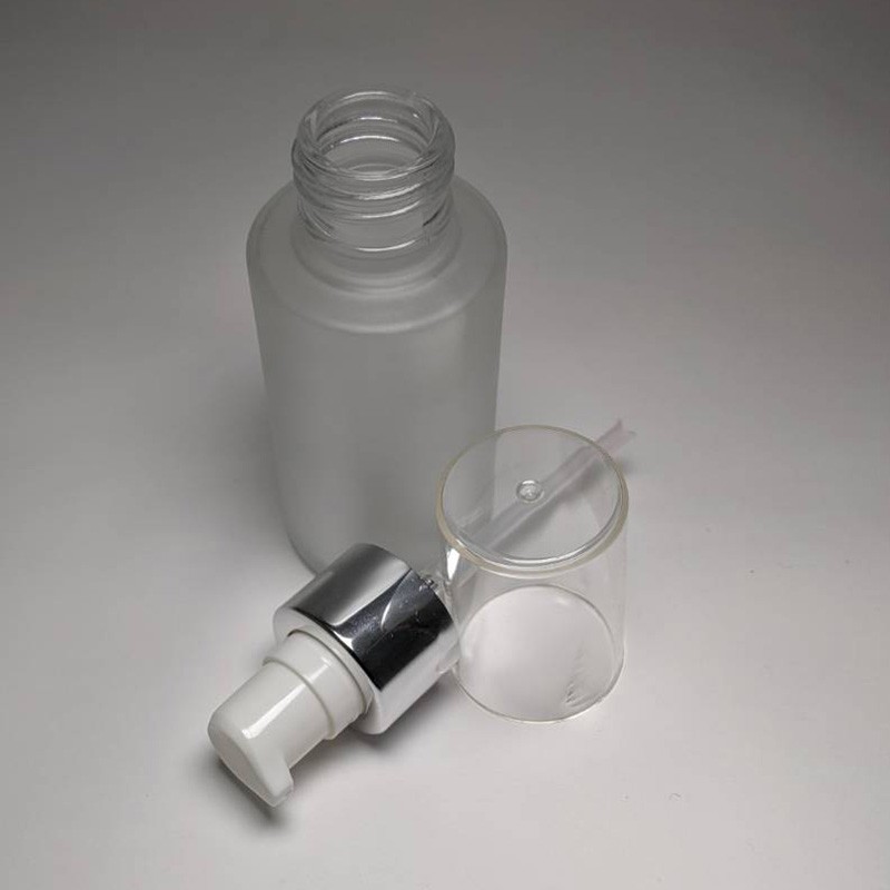 Make up base packaging cylinder shape glass bottle custom matte blue color 60ml capacity with white lotion pump