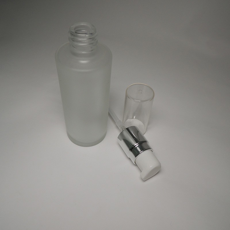 Medium size skincare cosmetic packaging empty 50ml cylinder shape glass bottle matte finish with cream/lotion pump and oversize cap